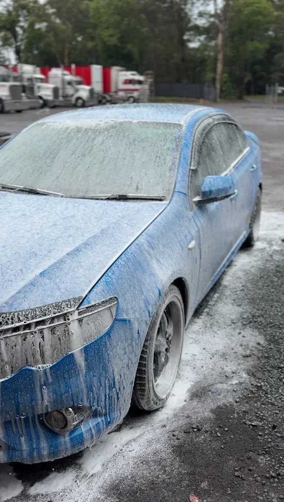 Blue Ford Falcon covered in snow foam pre-wash